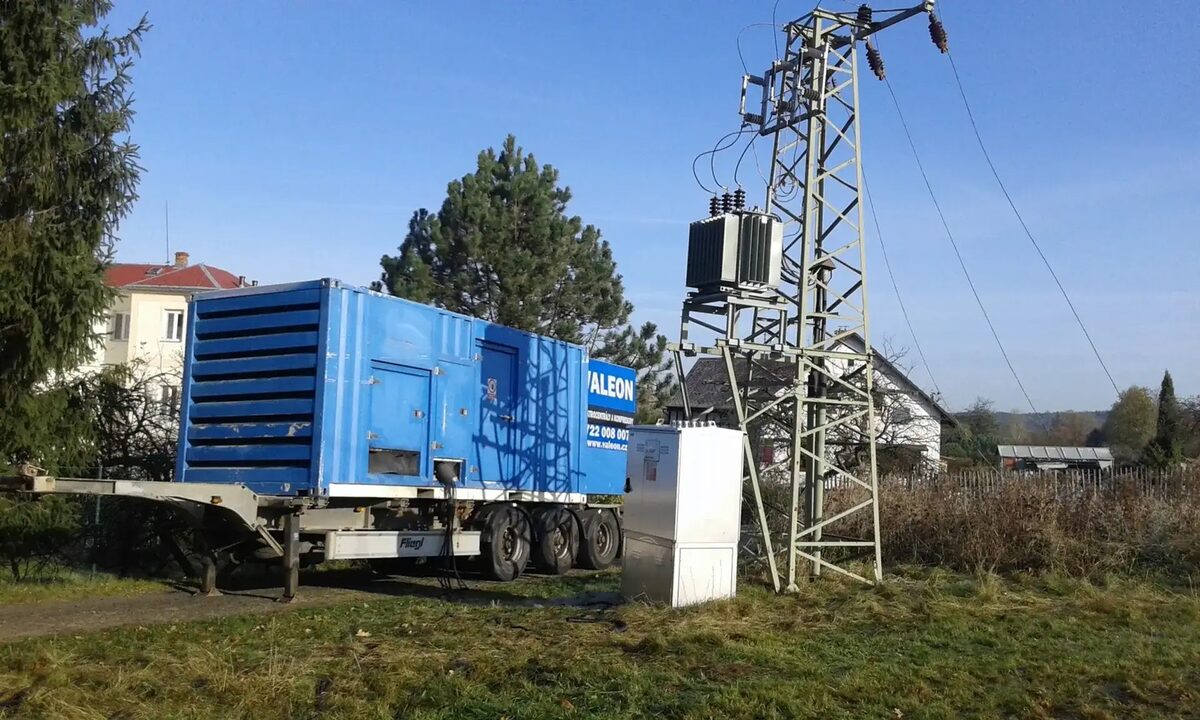 Kontejnerová elektrocentrála Valeon na návěsu vedle sloupové trafostanice na okraji obce