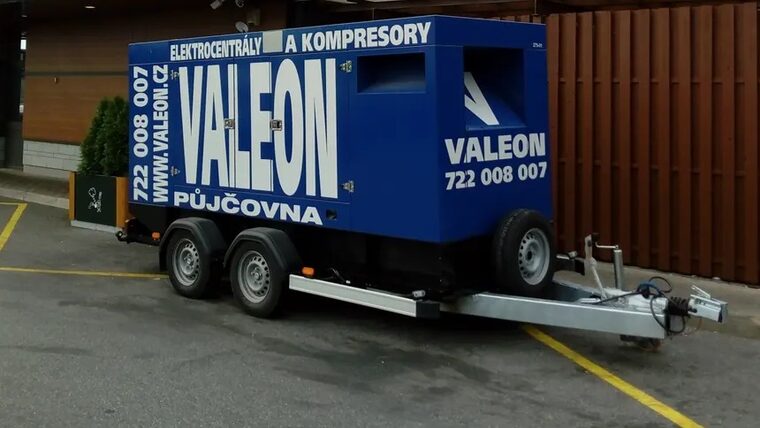 Mobilní elektrocentrála Valeon na dvounápravovém přívěsu na parkovišti u restaurace